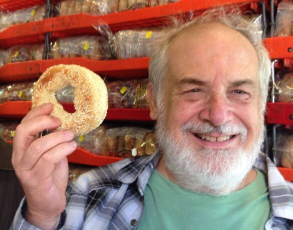 Photo of Michael Tobis holding a bagel