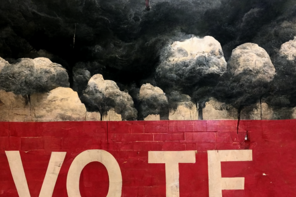 Image of dark clouds above a sign that says "vote."