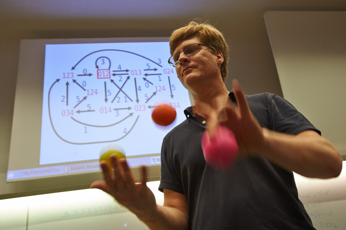 Photo of Colin Wright, juggliing in front of a juggling notation. Do you see an error in the notation?