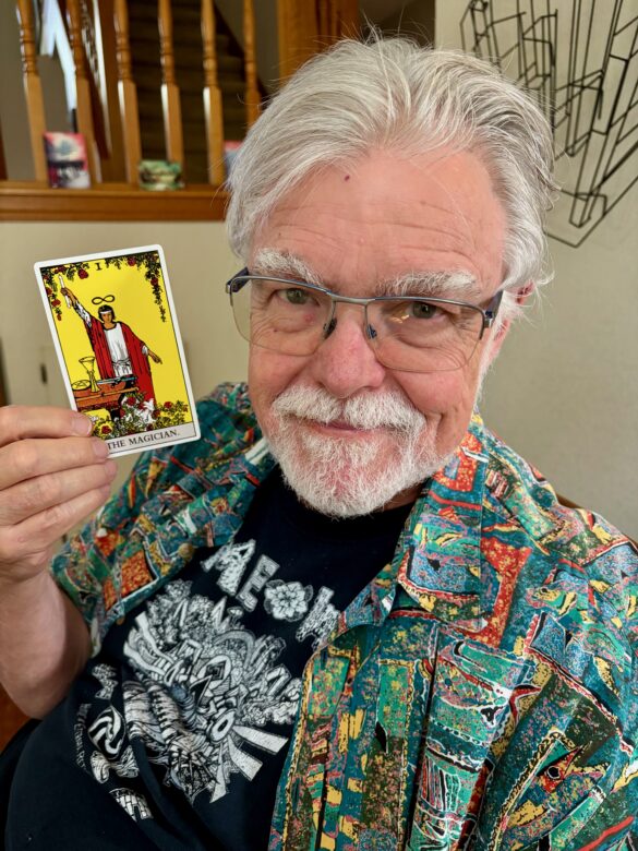 Photo of Jon Lebkowsky holding "The Magician" Tarot card.